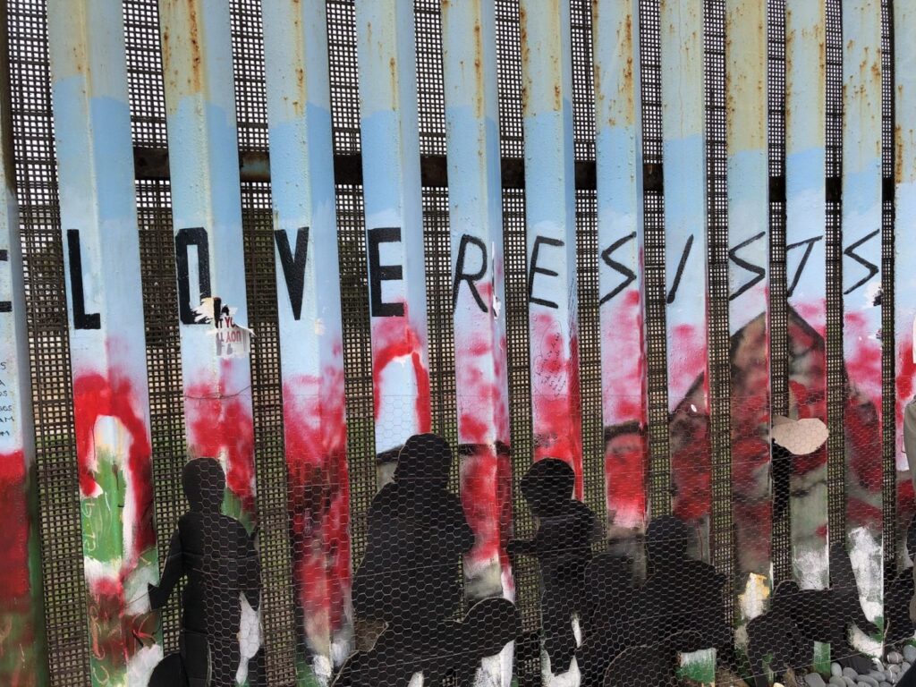 "Love Resists" graffiti on a wall.