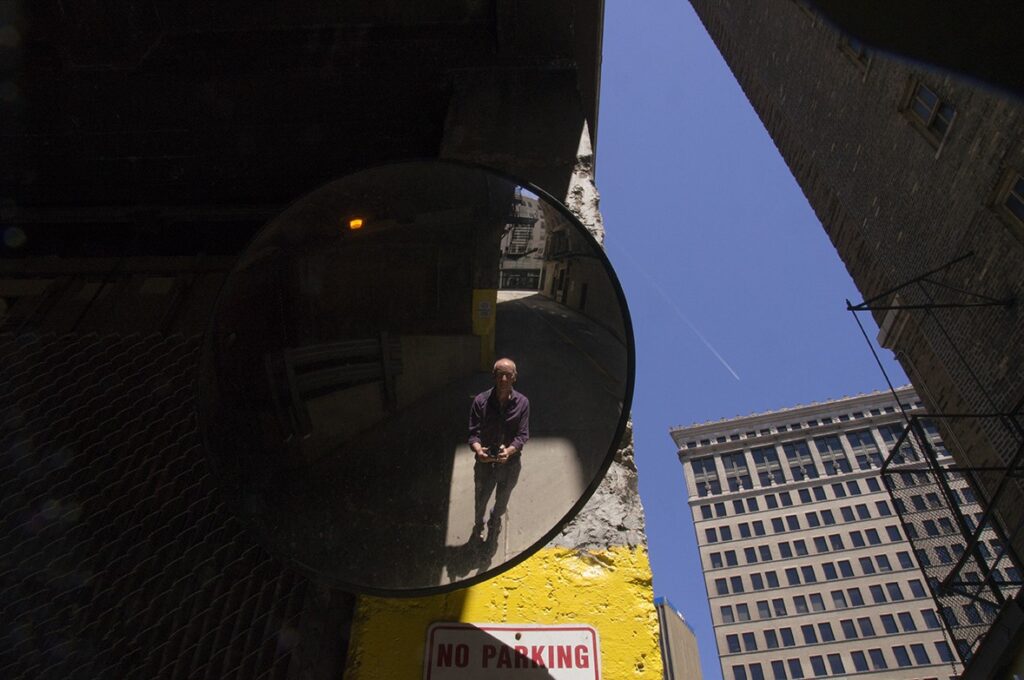 self portrait of Dick Blau: Blau reflected in a parking garage mirror