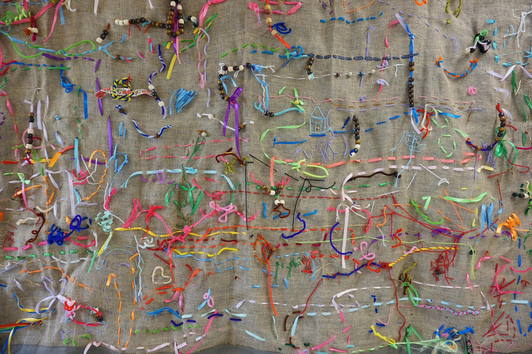 Children’s-Learning-Center-Tapestry UWM Children's Learning Center, We Are All Connected, 2022, Burlap, yarn, ribbon, beads, pipe cleaners, fabric